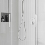 Lifestyle image of the Roca Flex Matt White 1500mm Anti-Twist Shower Hose installed in a shower cubicle