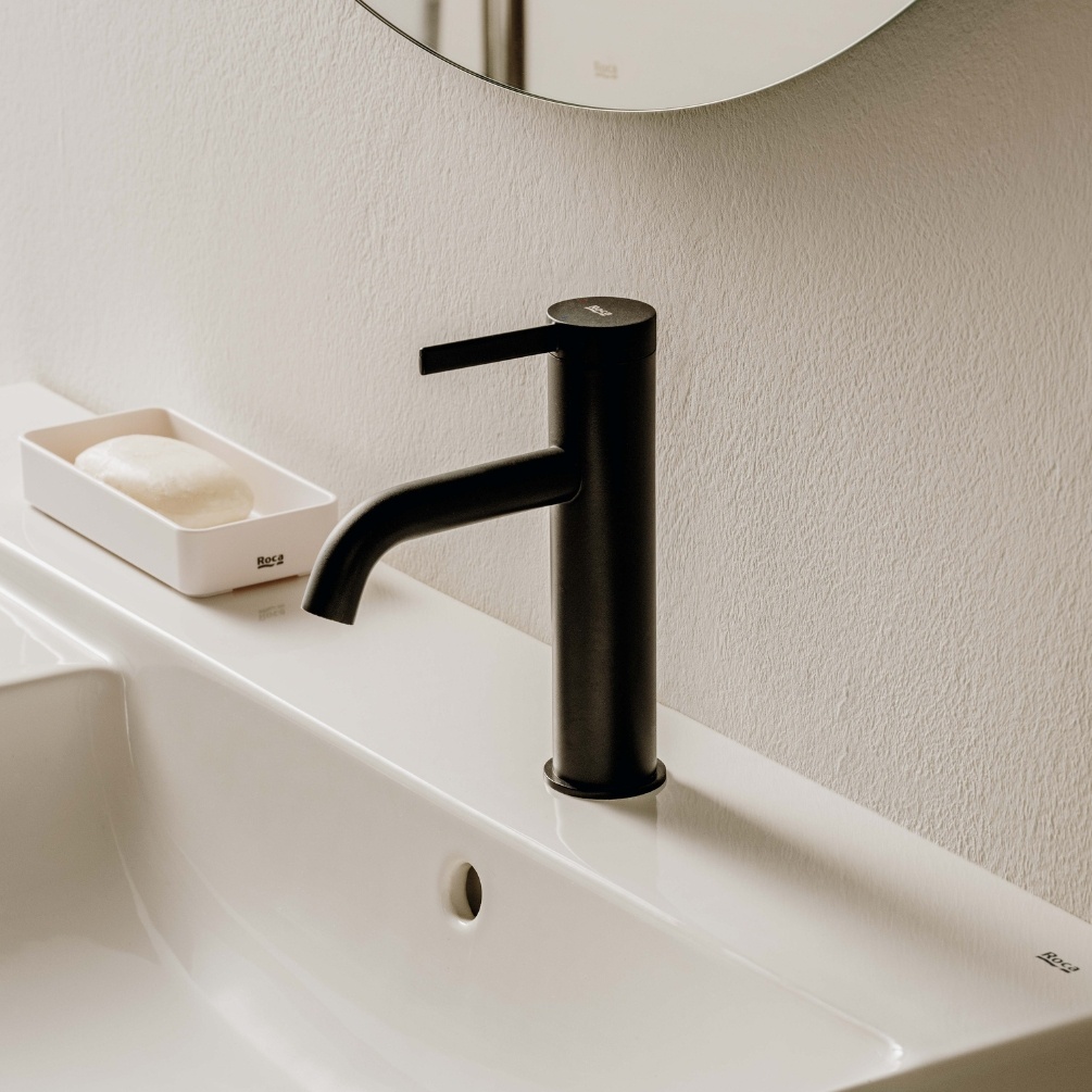 Lifestyle image of the Roca Ona Matt Black Basin Mixer Tap with Click-Clack Waste mounted on a basin deck