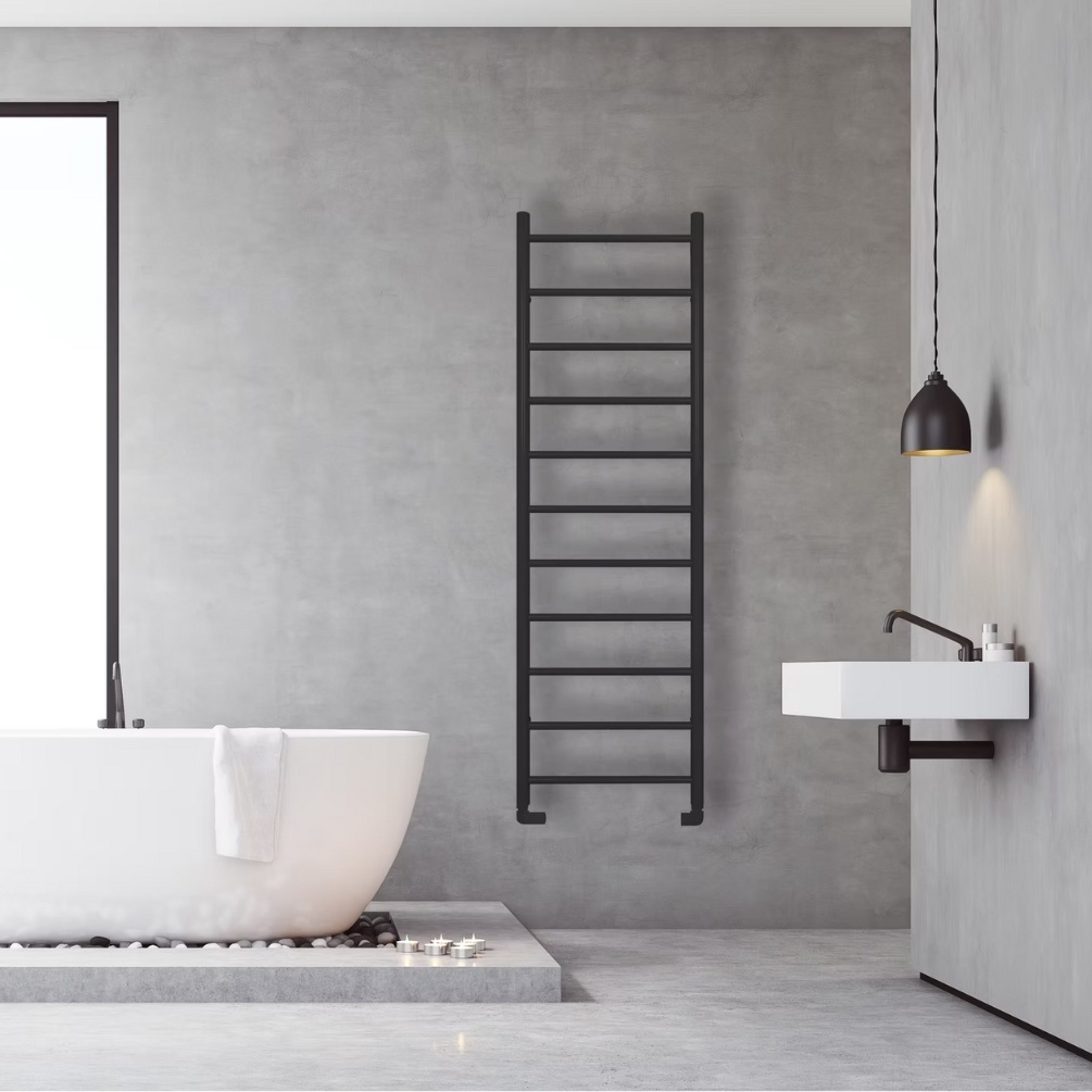 Lifestyle image of the Radox Space 1700mm x 538mm Matt Black Heated Towel Rail mounted in between a freestanding bath and wall-mounted basin