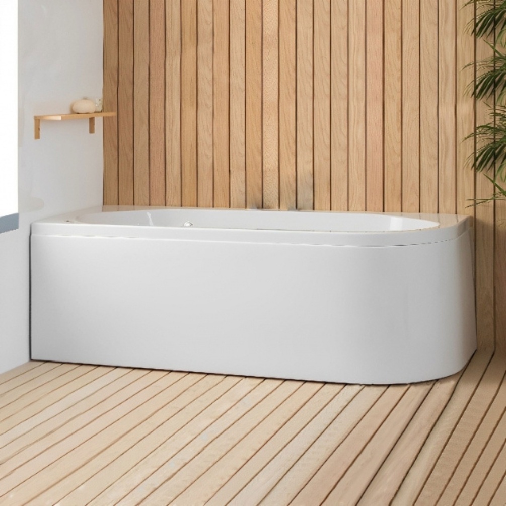 Lifestyle image of the Carron Status 1600mm x 725mm Corner Bath installed on wooden flooring, with a wall-mounted bath filler.