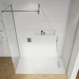 image of a frameless wet room screen and side panel in a white brick tiled bathroom with shower tray and parquet flooring