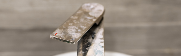 Close up image of a tap covered in limescale