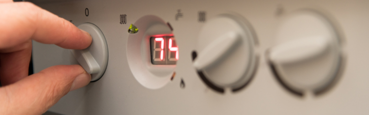 Close up image of a man adjusting the settings on his combination boiler