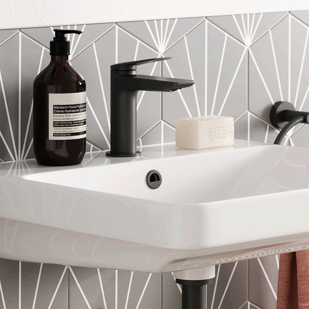 Photo of the Hoxton Overflow Cover in Matt Black with grey tiles
