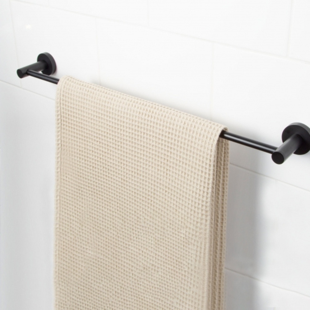 Lifestyle image of the Bristan Round Black Towel Rail with towel hanging