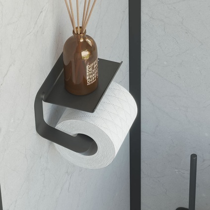 Lifestyle image of Origins Living Sonia Quick Toilet Roll Holder with Shelf Black mounted on marble white wall with incense sticks on shelf.