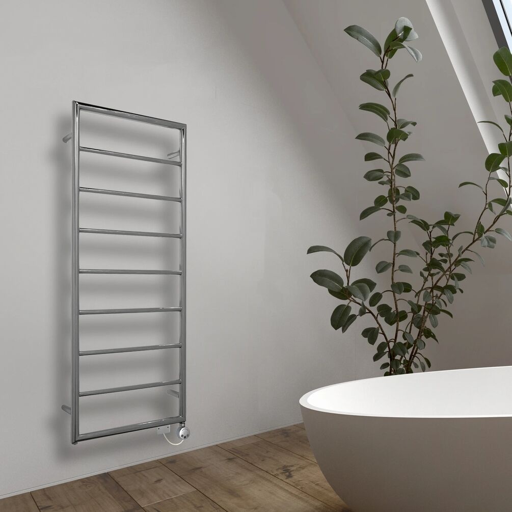 Lifestyle image of the The Sussex Range by JIS Alfriston 1260mm x 520mm Polished Stainless Steel Heated Towel Rail mounted on a white bathroom wall, near a freestanding bathtub