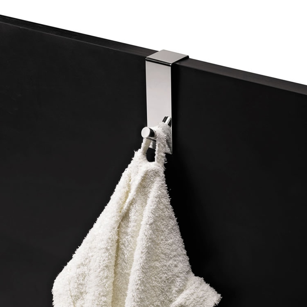 Cutout image of Origins Living Gedy Single Over-the-Door Hook mounted on black panel.