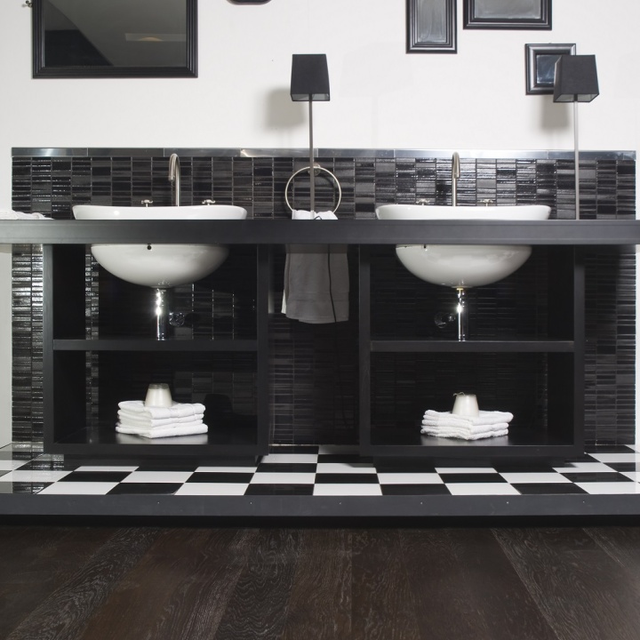 Lifestyle image of a black and white bathroom with double washbasin units