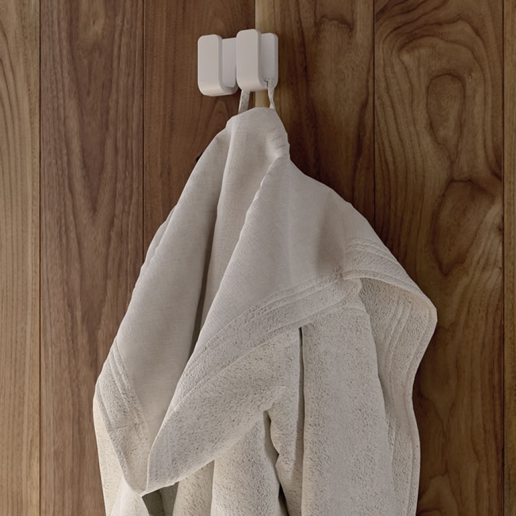 Lifestyle image of Origins Living Gedy Outline Double Hook white mounted on wooden wall.
