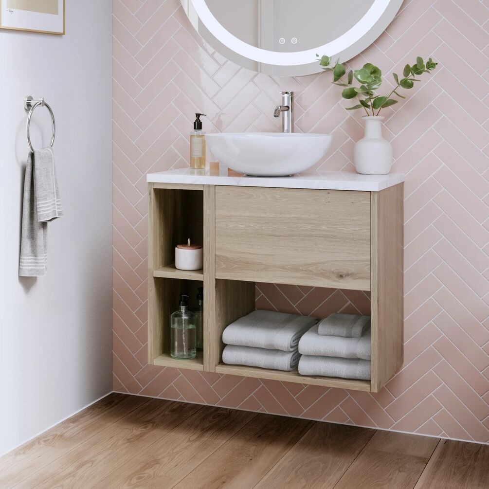Lifestyle image of the Britton Hackney Cherry Wood 700mm Wall Hung Vanity Unit with Carrara Worktop & Shelf Unit with countertop basin and mixer tap, installed next to a towel ring and below a round mirror