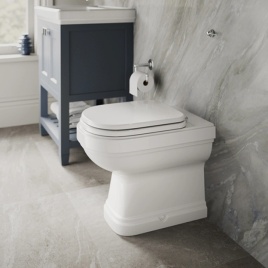 image of a burlington back to wall toilet from side angle in marble bathroom with grey floor & blue vanity unit behind