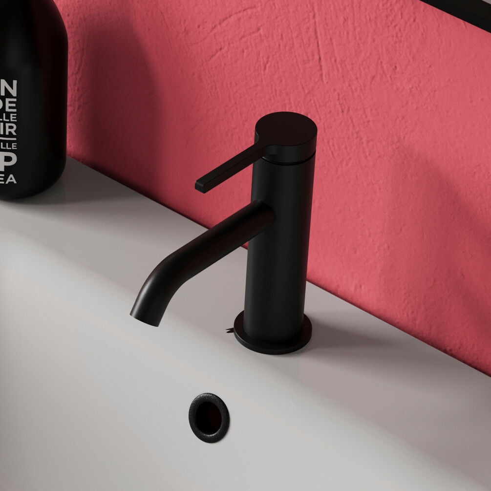 product lifestyle image of Britton Hoxton 2.0 Slim Mono Basin Mixer close up on basin next to salmon pink wall HOX110DNM