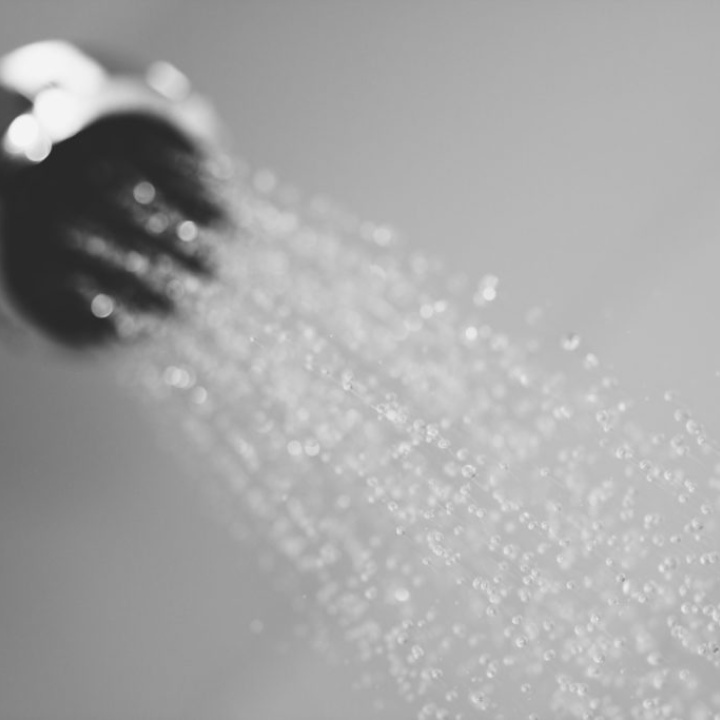 Close up lifestyle image of water spraying from a handset shower head