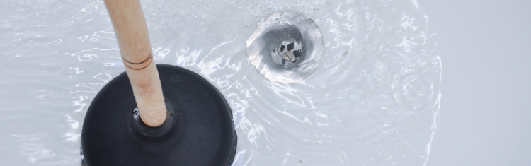 Close up image of a pluner next to a bath plughole