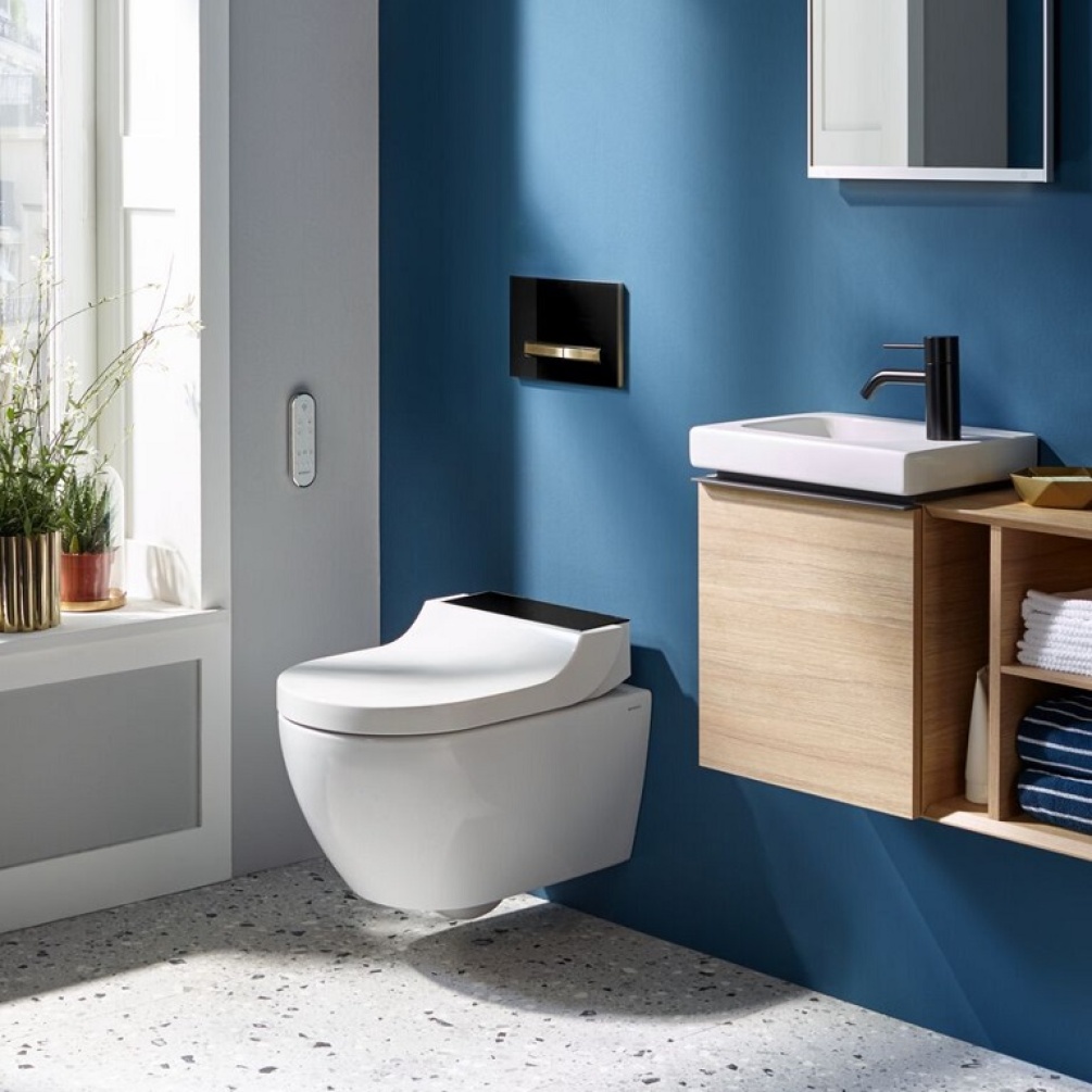 Product Lifestyle Image of Geberit AquaClean Tuma Rimless Comfort Smart Wall Hung Bidet Shower Toilet with Black Glass Design Cover against blue bathroom wall - 146.290.SJ.1