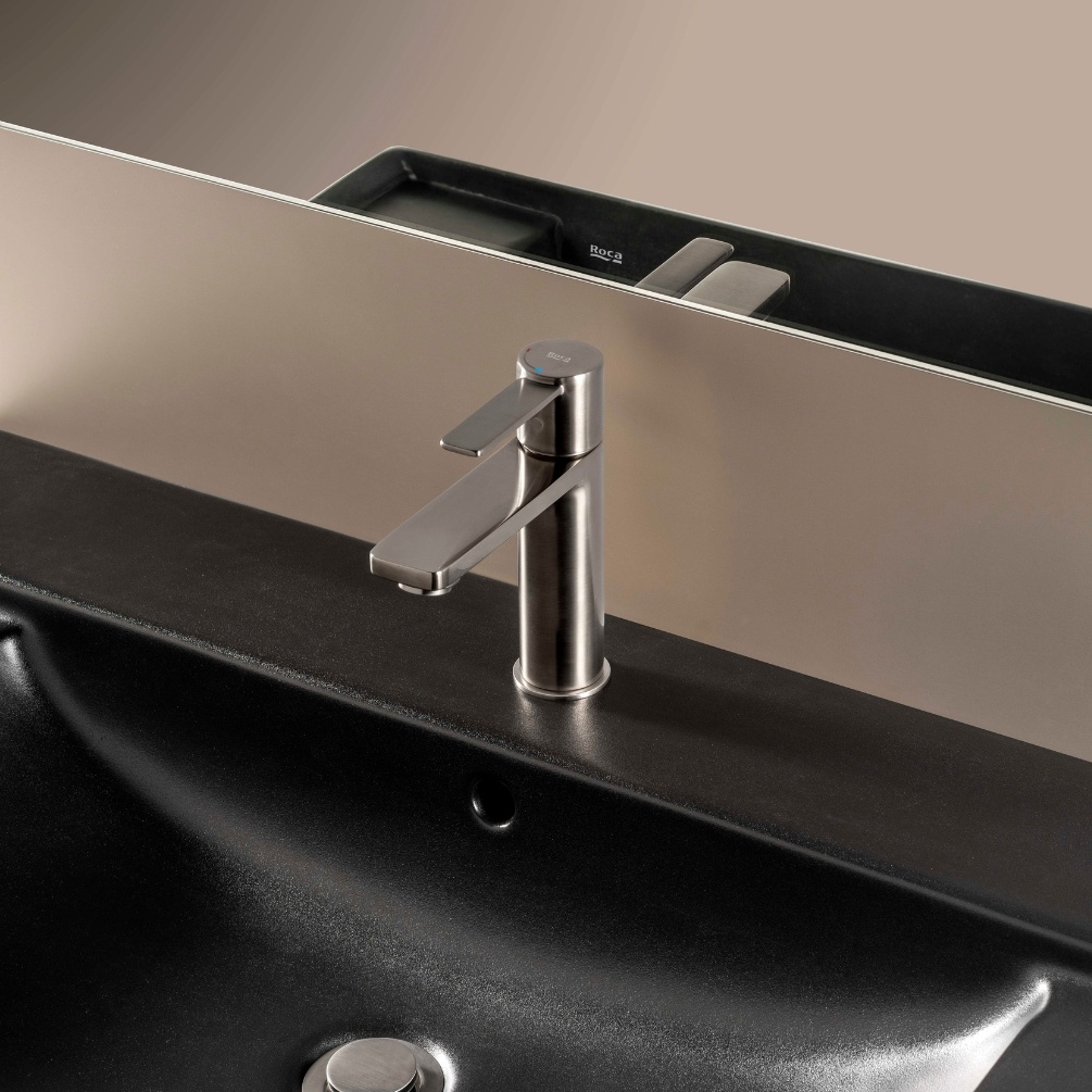 Lifestyle image of the Roca Targa Chrome Basin Mixer Tap mounted on a black basin