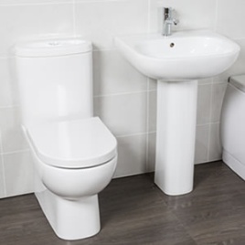 image of a contemporary toilet and basin set. It includes a close coupled toilet on a brown floor and white tiled wall, and a pedestal basin with overflow and chrome mono tap