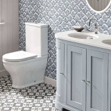 Lifestyle image of the Tavistock Lansdown Close Coupled Short Projection Back to Wall Toilet installed next to a double vanity unit with basins