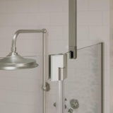 Close up product lifestyle image of the Burlington Brushed Nickel Glass to Ceiling Bracing Bar supporting a single pane of glass