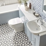 Lifestyle image of the Tavistock Lansdown Back To Wall Comfort Height Toilet installed in a blue toilet & sink vanity unit