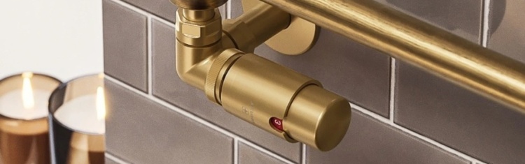 image of a close up of a brushed brass radiator valve thermostatic control