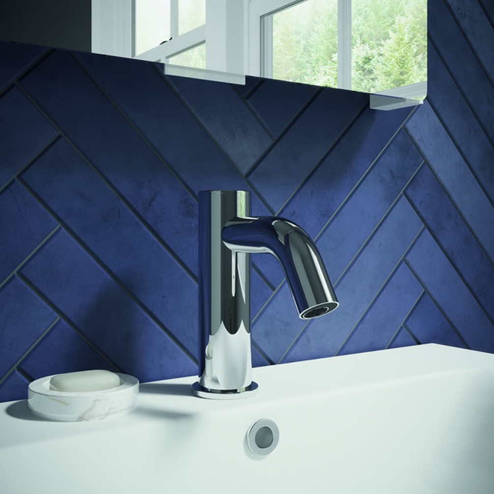 Lifestyle image of MPRO Sensor Basin Monobloc chrome mounted on white basin against dark blue tiled wall.
