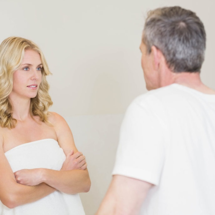 Staged image of a couple arguing, the woman crossing her arms and looking unimpressed at whatever the man is saying
