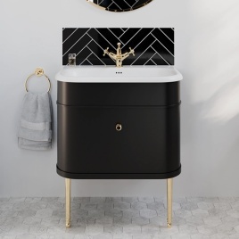 image of a burlington chalfont matt black vanity unit with gold legs and handles in front of black herringbone tiled area
