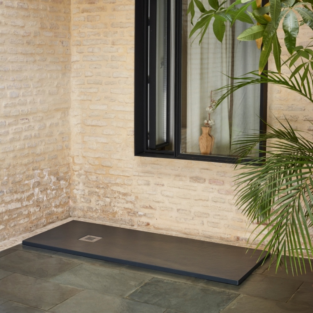 Product Lifestyle image of the Doccia Lipari Graphite Slate 1600mm x 900mm Shower Tray in a room with brick walls