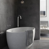 Lifestyle image of Vado Geo Floor Standing Bath Spout in grey themed modern bathroom.